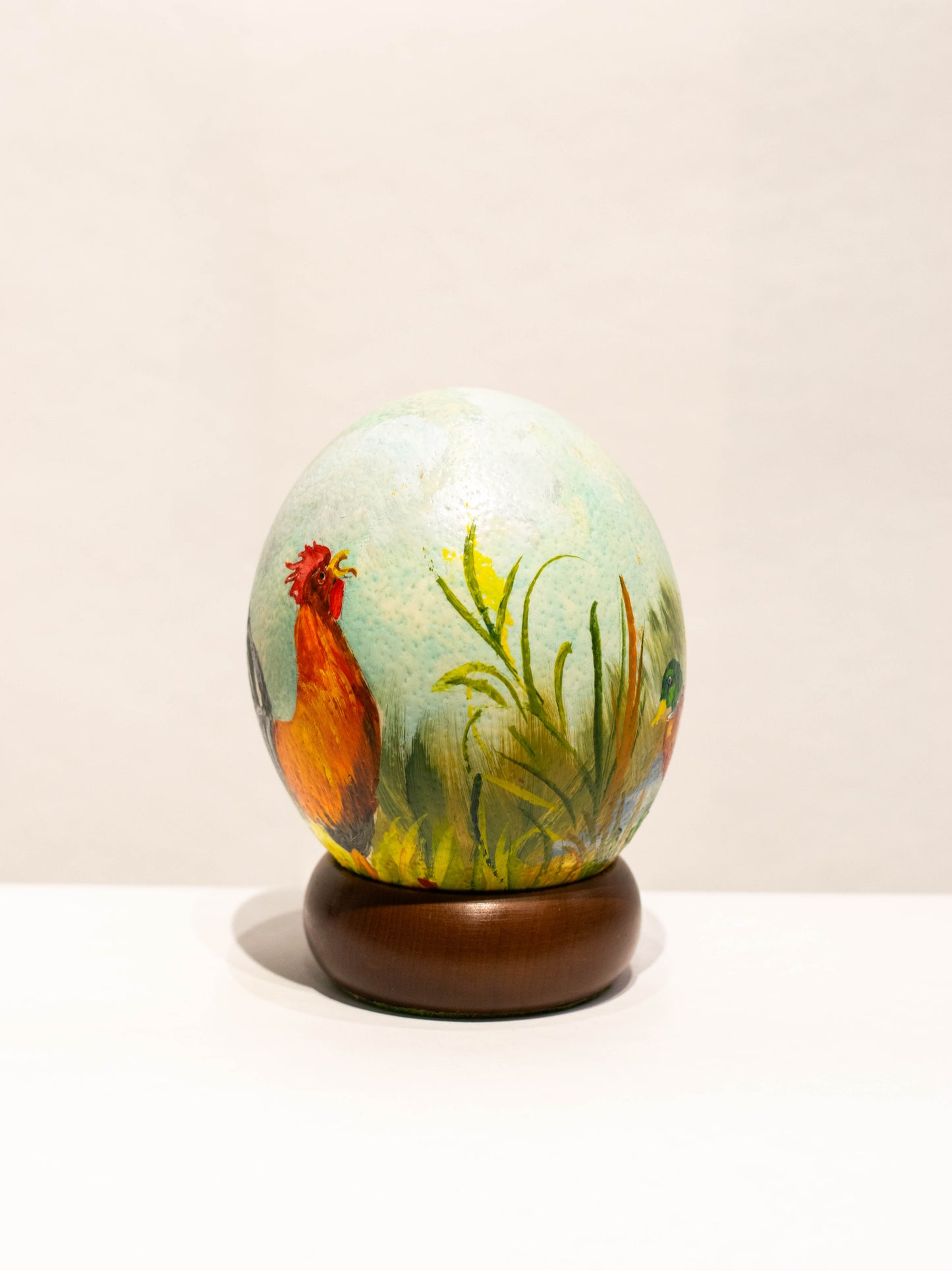 Handbemaltes Straußenei, hellblau mit Entenpaar und Hahn, auf Holzsockel, Kurt Wicha (*1940), Mendig